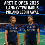 aDua atlet bulu tangkis putri Indonesia, Lanny Tria Mayasari dan Amallia Cahaya Pratiwi, sedang bertanding di lapangan bulu tangkis Arctic Open 2025 di Finlandia dengan nuansa biru es dan atmosfer kompetitif